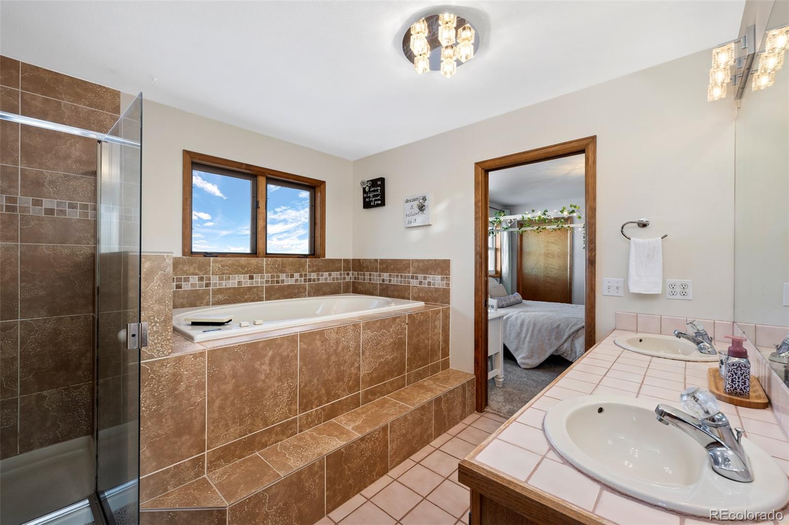 4205 West Parkridge Road Sedalia, CO 80135 - Photo 42 of 50 a spacious bathroom with a tub sink and mirror