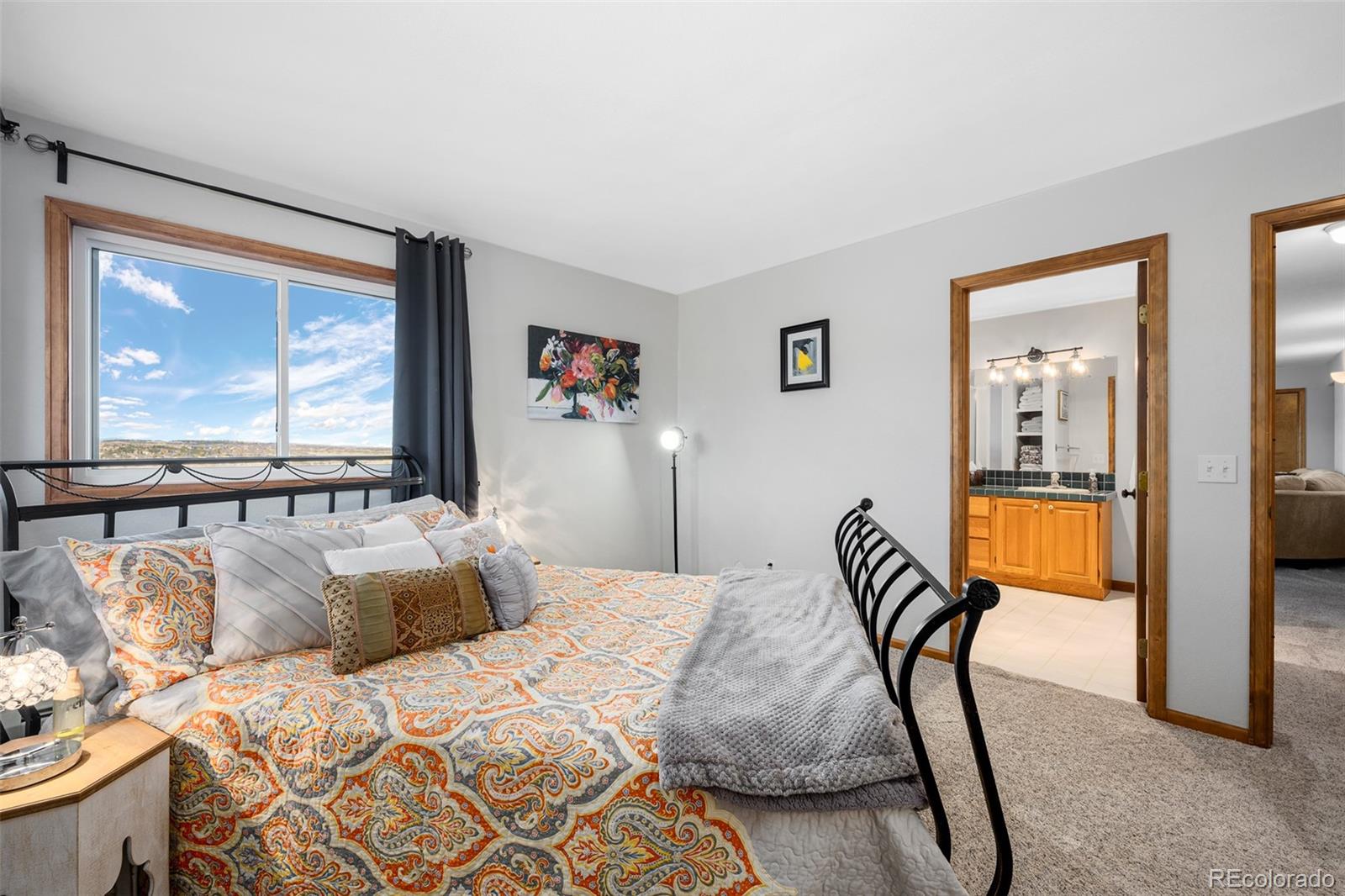 4205 West Parkridge Road Sedalia, CO 80135 - Photo 45 of 50 a bedroom with a bed and glass windows