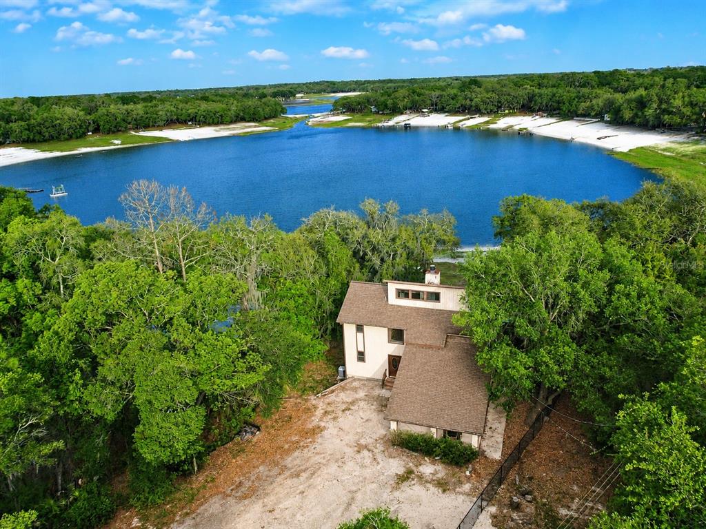 7119 Immokalee Road Keystone Heights, FL 32656 - Photo 1 of 50 an aerial view of a house with a garden and lake view