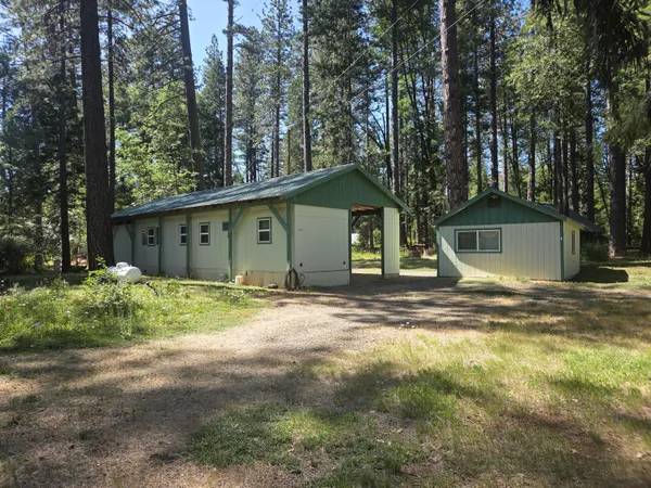 a view of a house with a yard and large tree
