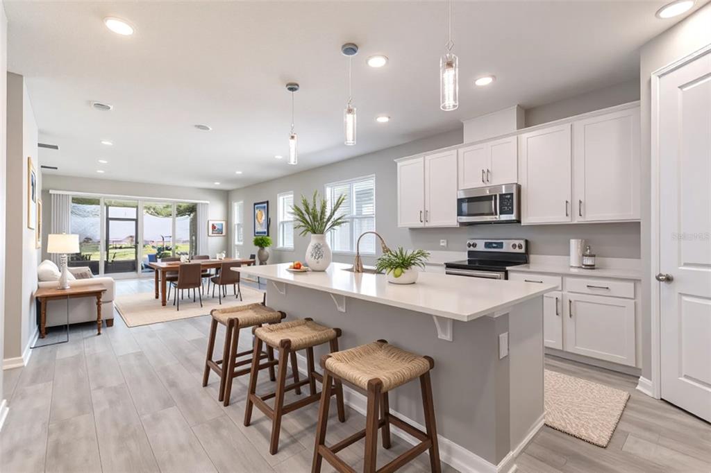 10361 Church Hammock Road Leesburg, FL 34788 - Photo 11 of 46 a kitchen with white cabinets and stainless steel appliances