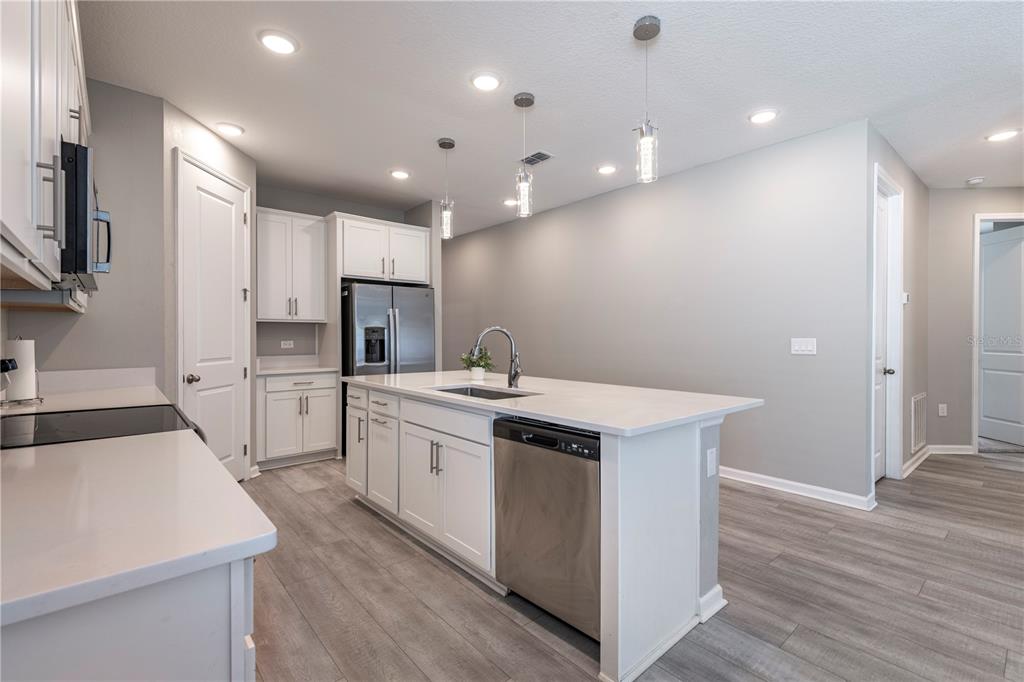 10361 Church Hammock Road Leesburg, FL 34788 - Photo 12 of 46 a kitchen with kitchen island a sink stainless steel appliances and cabinets