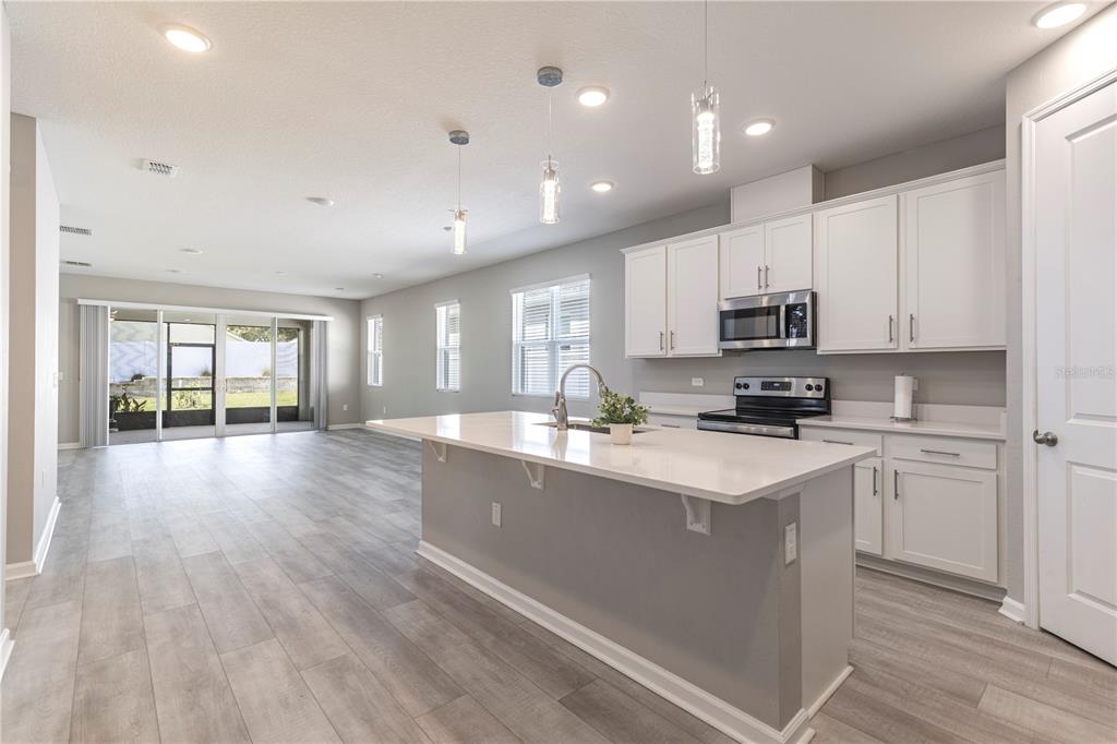 10361 Church Hammock Road Leesburg, FL 34788 - Photo 15 of 46 a large kitchen with stainless steel appliances granite countertop a lot of counter space and wooden floors
