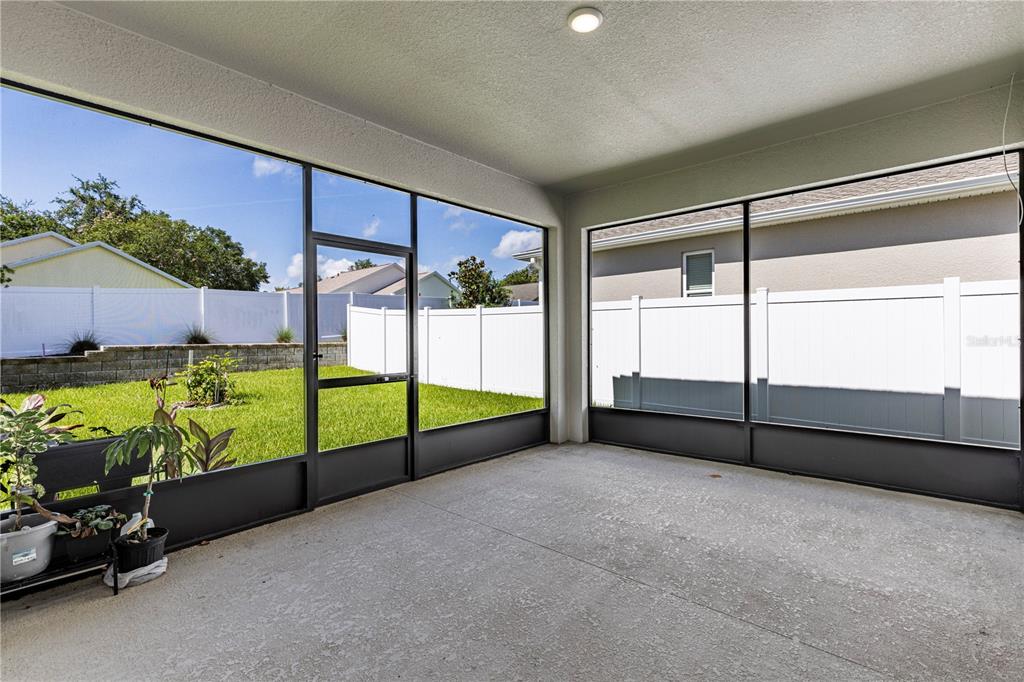 10361 Church Hammock Road Leesburg, FL 34788 - Photo 37 of 46 a view of an empty room with a floor to ceiling window and potted plants
