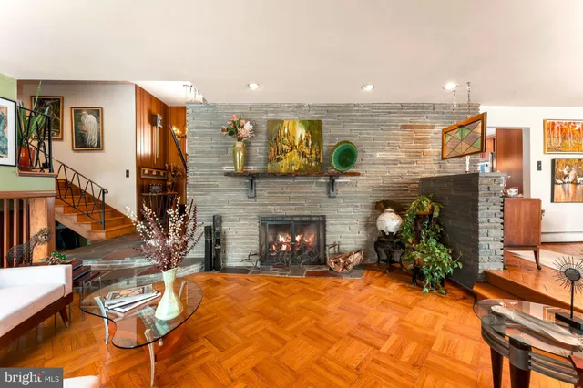 a living room with furniture fireplace and potted plants