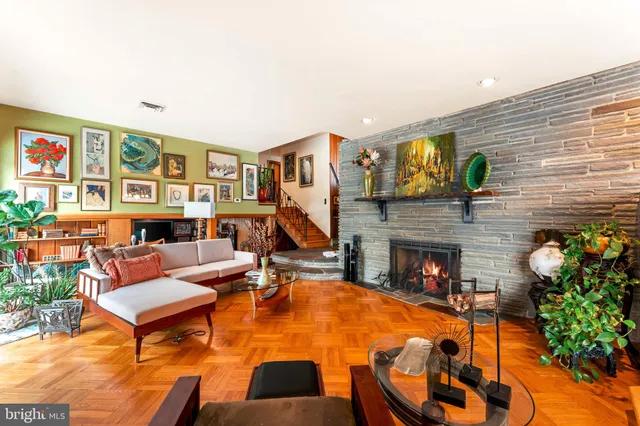 a living room with furniture a fireplace and a large window