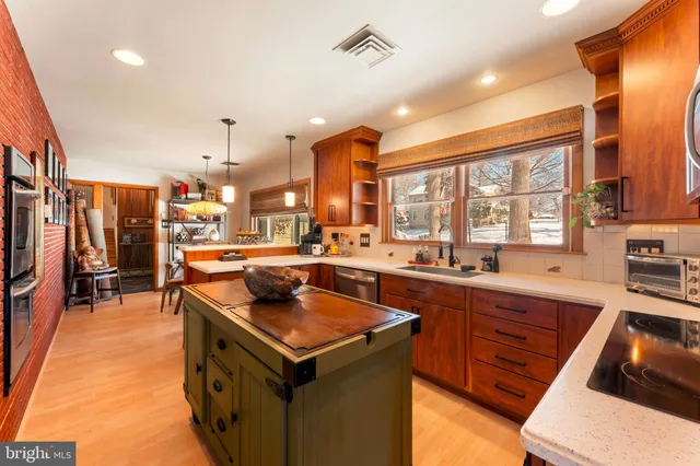 a kitchen with stainless steel appliances granite countertop a sink a stove and a refrigerator