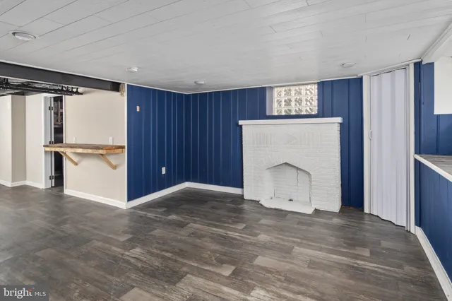 a view of an empty room with a window and kitchen view