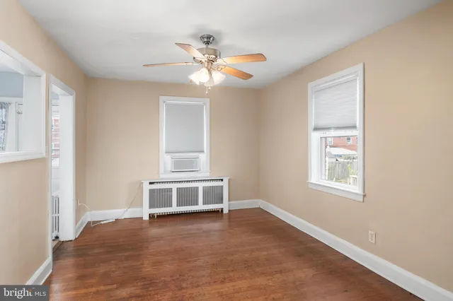 a view of an empty room with wooden floor and stairs