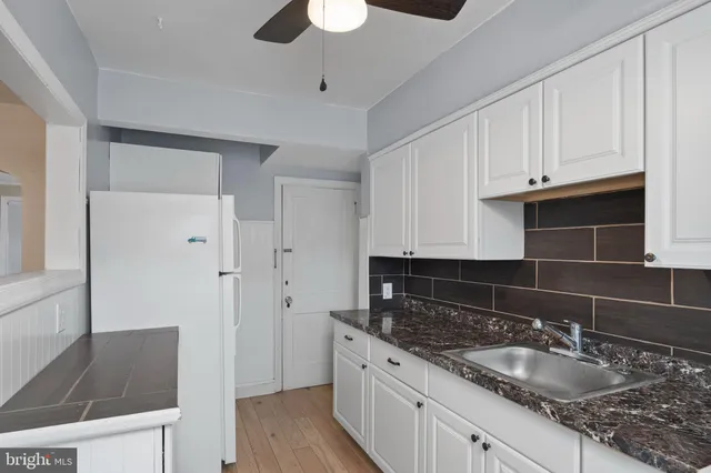 a kitchen with granite countertop a sink and a stove top oven