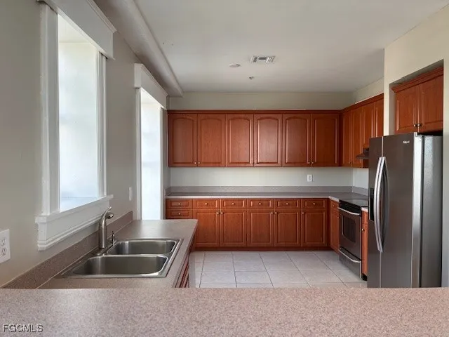 a kitchen with stainless steel appliances granite countertop a refrigerator and a sink