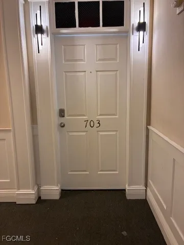 an empty room with a fireplace and large windows