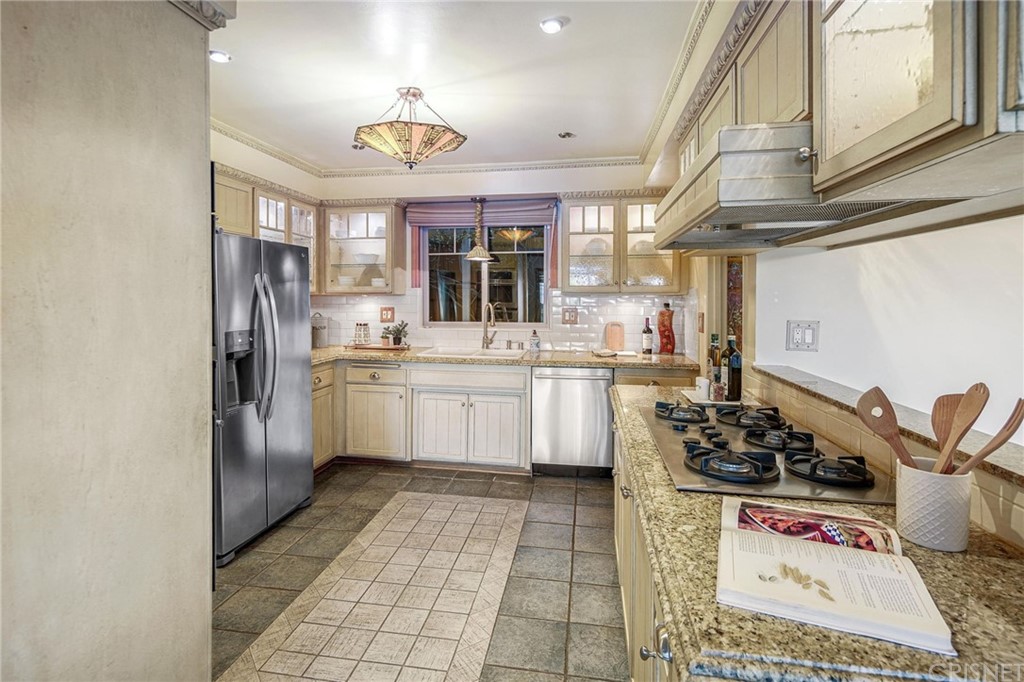 15098 Rayneta Drive Sherman Oaks, CA 91403 - Photo 17 of 43 a kitchen with stainless steel appliances a sink a stove a refrigerator and cabinets