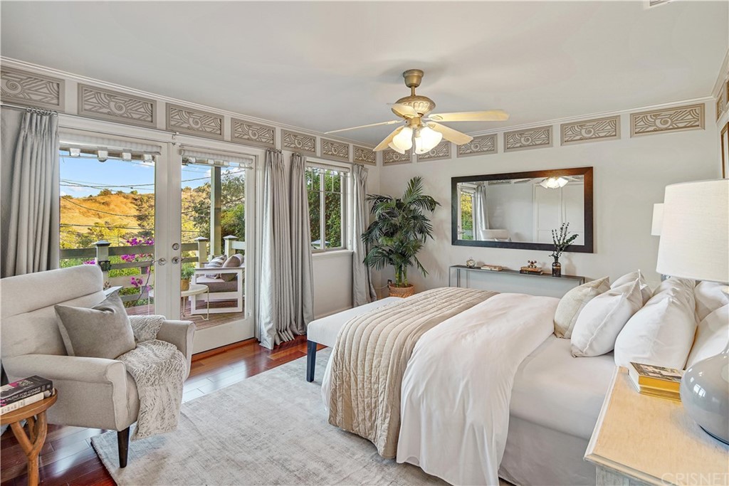 15098 Rayneta Drive Sherman Oaks, CA 91403 - Photo 19 of 43 a bedroom with a large bed and a chandelier