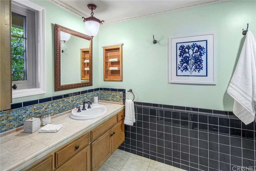 15098 Rayneta Drive Sherman Oaks, CA 91403 - Photo 24 of 43 a bathroom with a double vanity sink a mirror and a shower