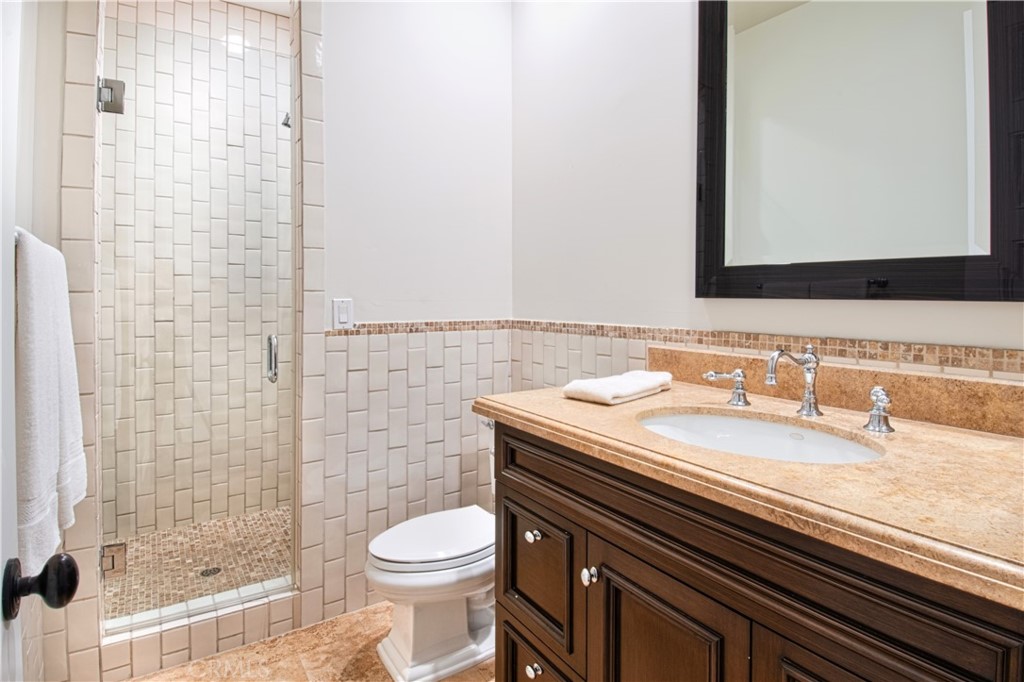 322 Emerald Bay Laguna Beach, CA 92651 - Photo 28 of 34 a bathroom with a granite countertop toilet sink and mirror