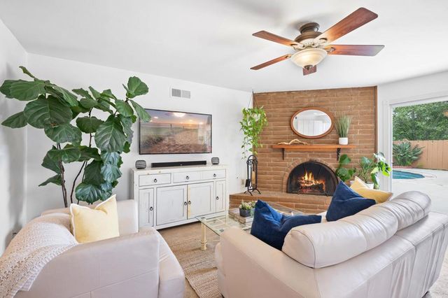 a living room with furniture a fireplace and a flat screen tv