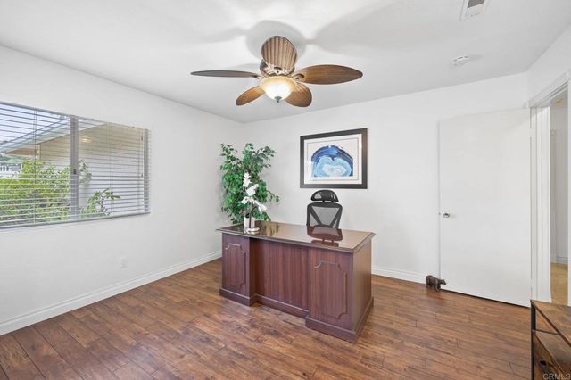 a view of a workspace with furniture and chandelier fan