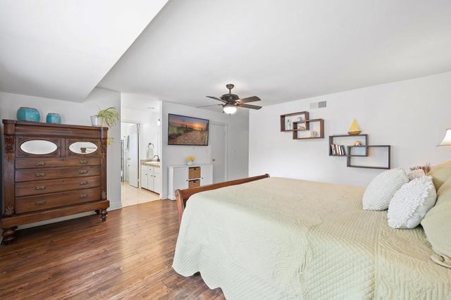 a spacious bedroom with a bed and wooden floor