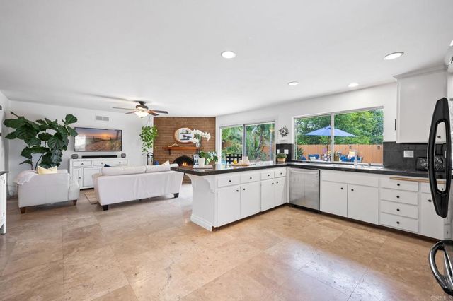 a large white room with kitchen island a flat screen tv