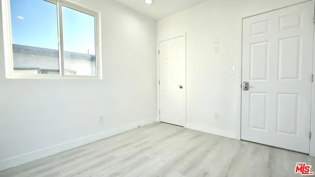 an empty room with wooden floor and sliding door