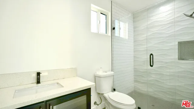 a bathroom with a sink a toilet and mirror