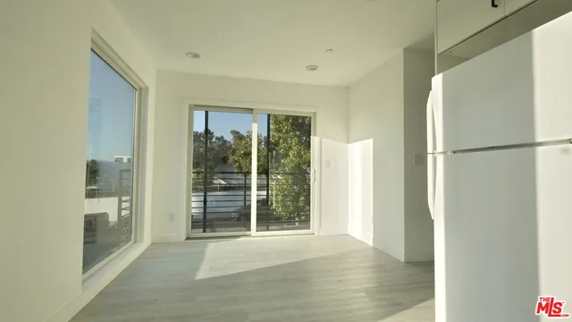 a view of a room with a floor to ceiling window and wooden floor