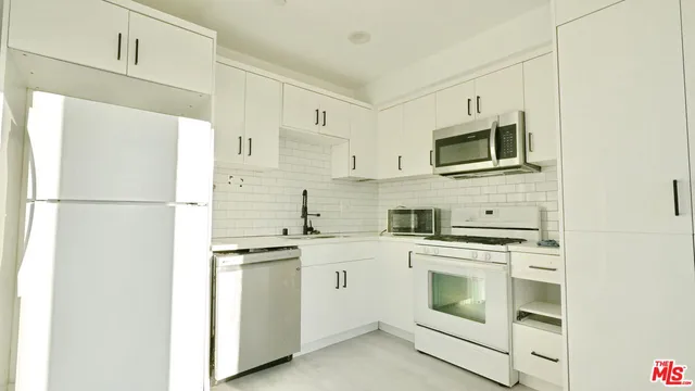 a kitchen with cabinets stainless steel appliances and a counter