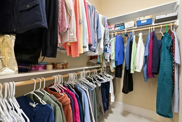 a view of walk in closet with clothes and shoes