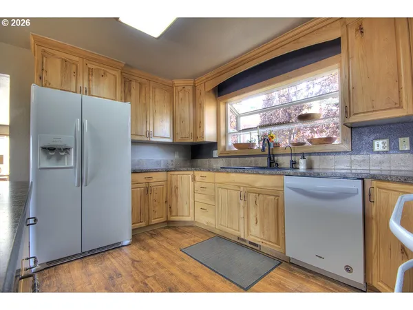 a kitchen with granite countertop wooden cabinets and a stove top oven