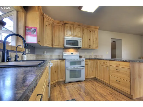a kitchen with kitchen island granite countertop a sink cabinets and wooden floor
