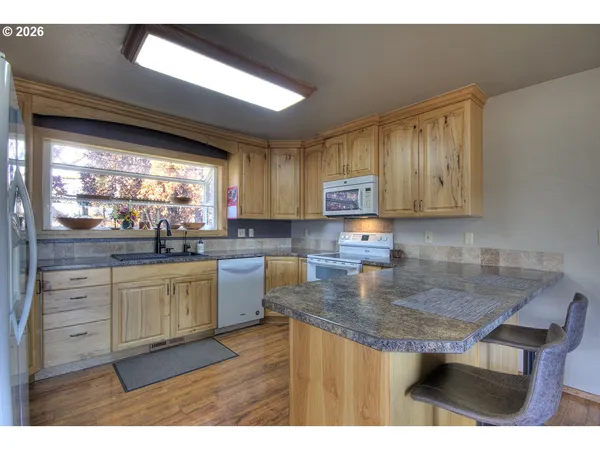 a kitchen with a dining table chairs and refrigerator