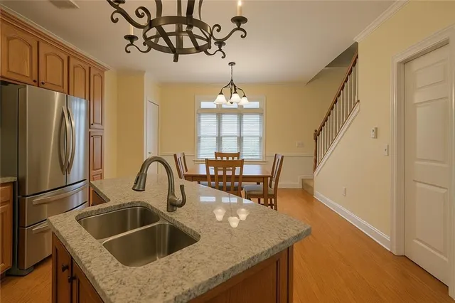 a kitchen with stainless steel appliances granite countertop a sink a stove and a refrigerator