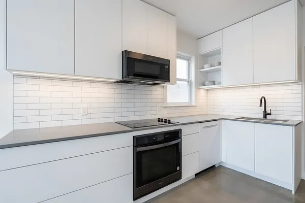 a kitchen with stainless steel appliances granite countertop a sink stove and microwave