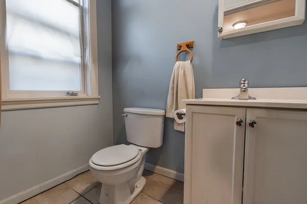 a bathroom with a toilet a sink and mirror