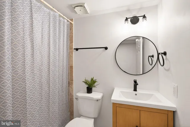 a view of a hallway with furniture and a bathroom