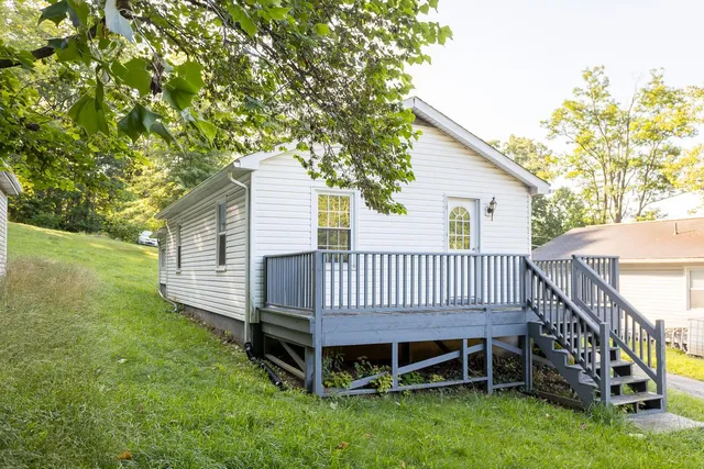 a view of a house with a yard and a deck
