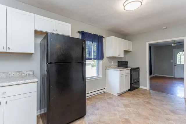 a kitchen with a refrigerator and a stove top oven
