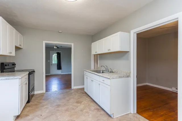 a kitchen with a sink a stove and cabinets