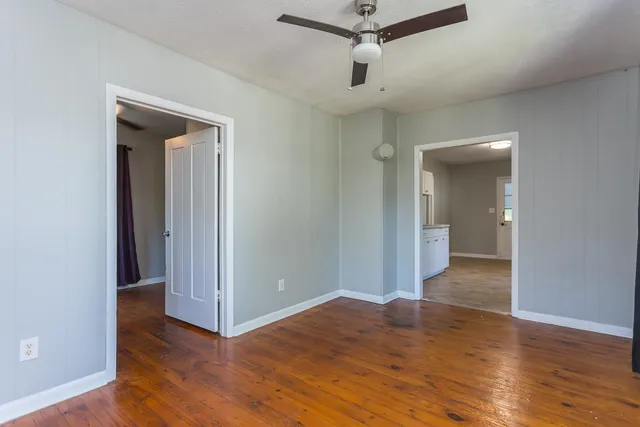 a view of empty room with wooden floor