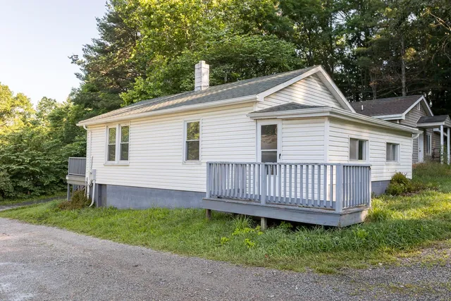 a view of a house with a yard and deck
