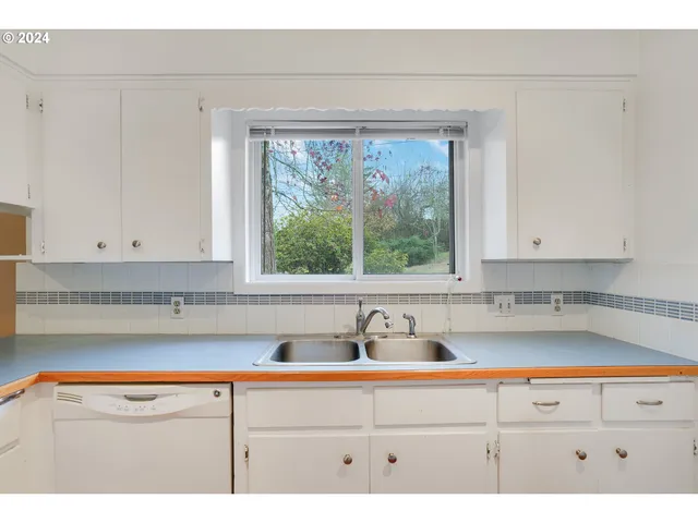 a sink with a window and cabinets