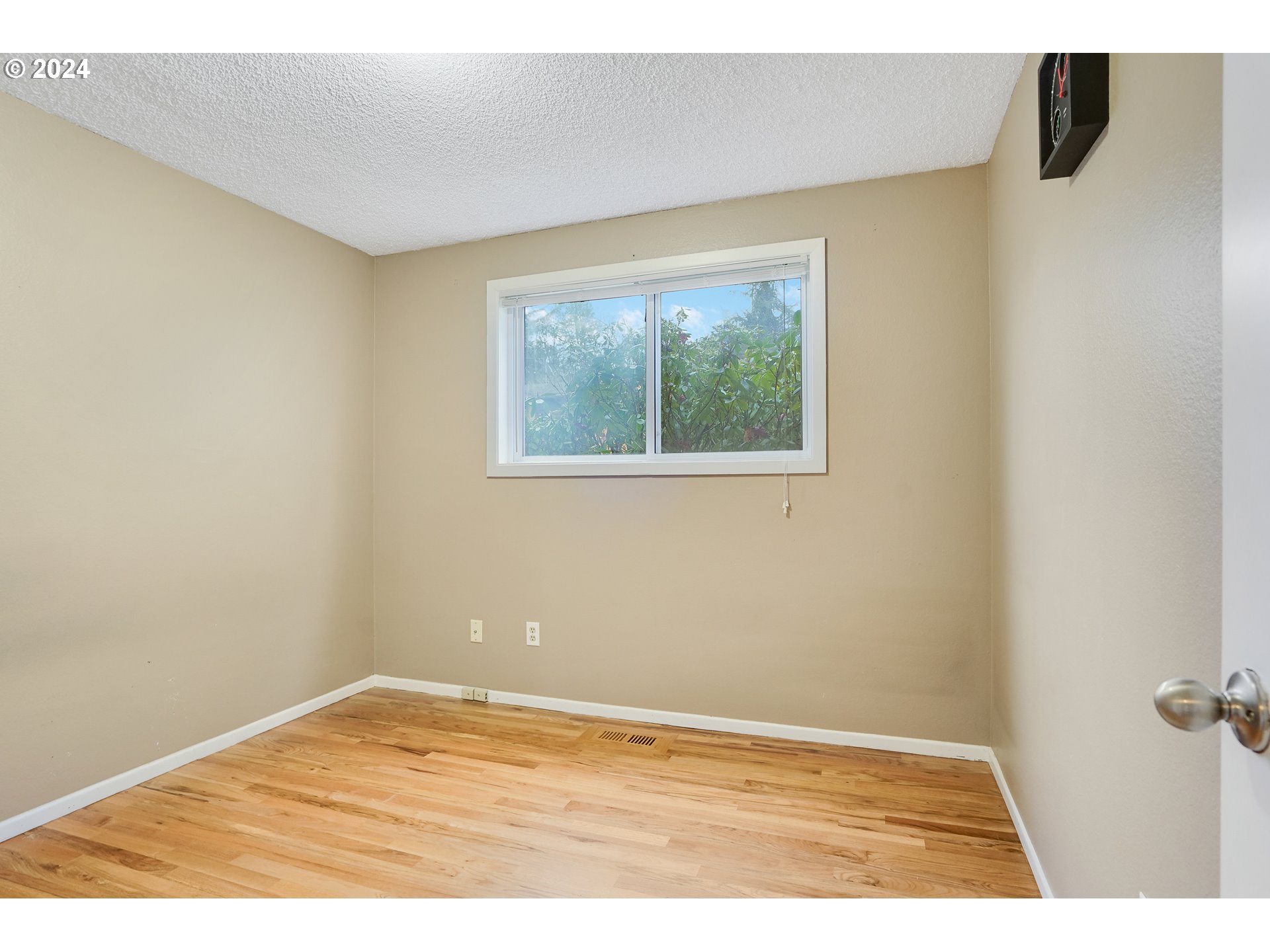 390 Northwest Conifer Boulevard Corvallis, OR 97330 - Photo 19 of 47 a view of an empty room with wooden floor and a window