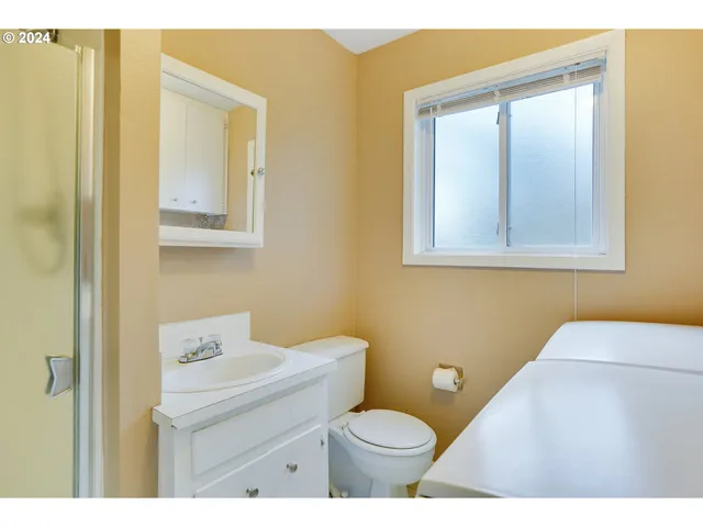 a bathroom with a toilet a sink a vanity and mirror