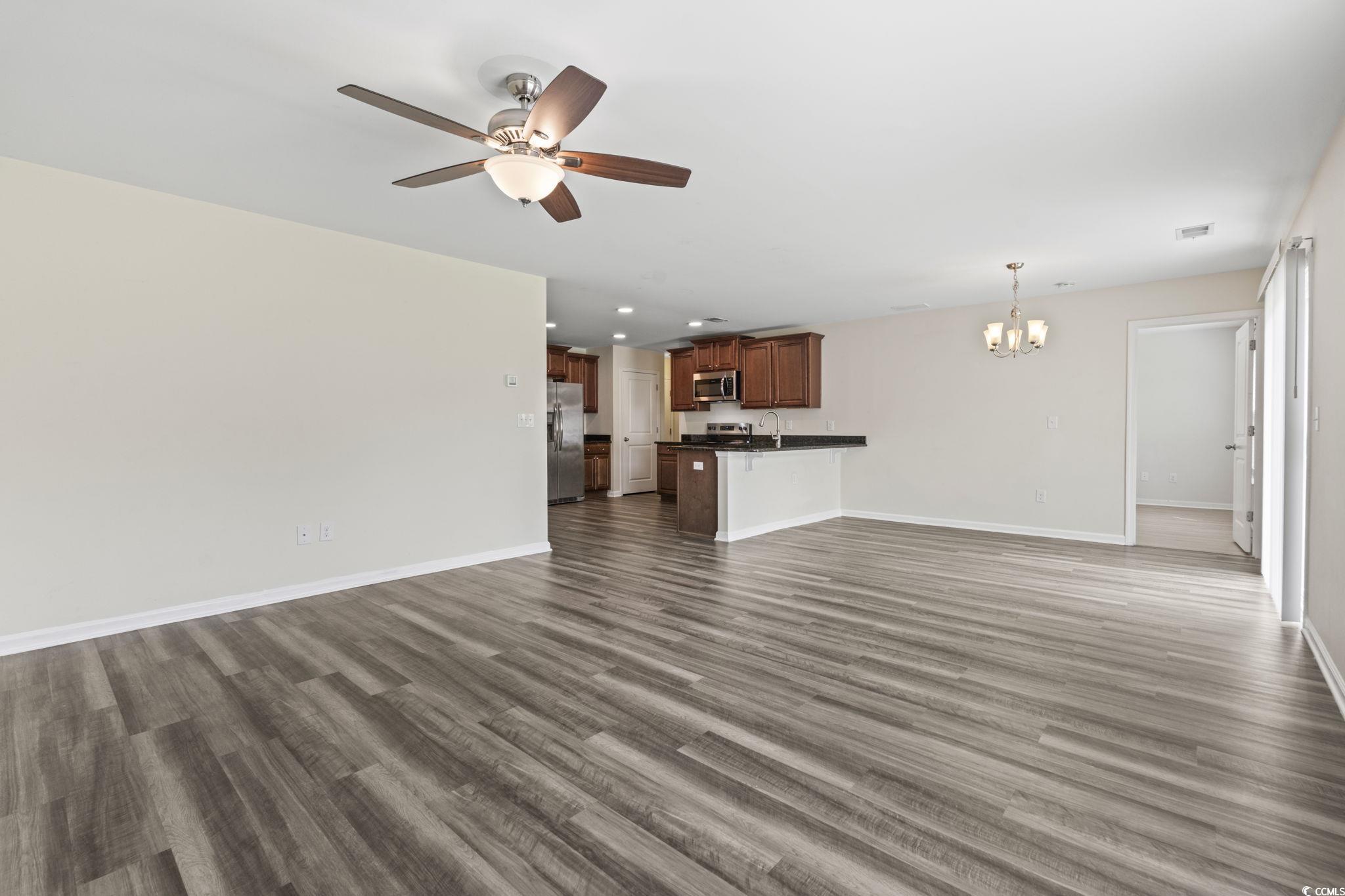 3151 Holly Loop Conway, SC 29527 - Photo 14 of 31 Unfurnished living room with a chandelier, a ceiling fan, and dark wood-style floors