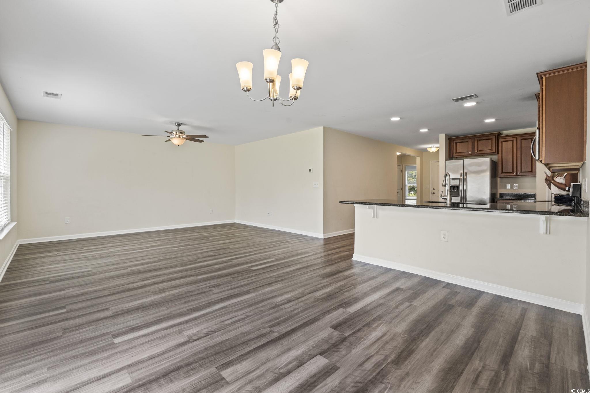3151 Holly Loop Conway, SC 29527 - Photo 30 of 31 Kitchen featuring dark countertops, a chandelier, open floor plan, ceiling fan, and dark wood-type flooring