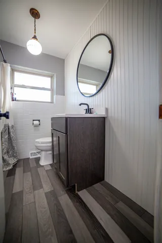 a spacious bathroom with a toilet a sink and a mirror