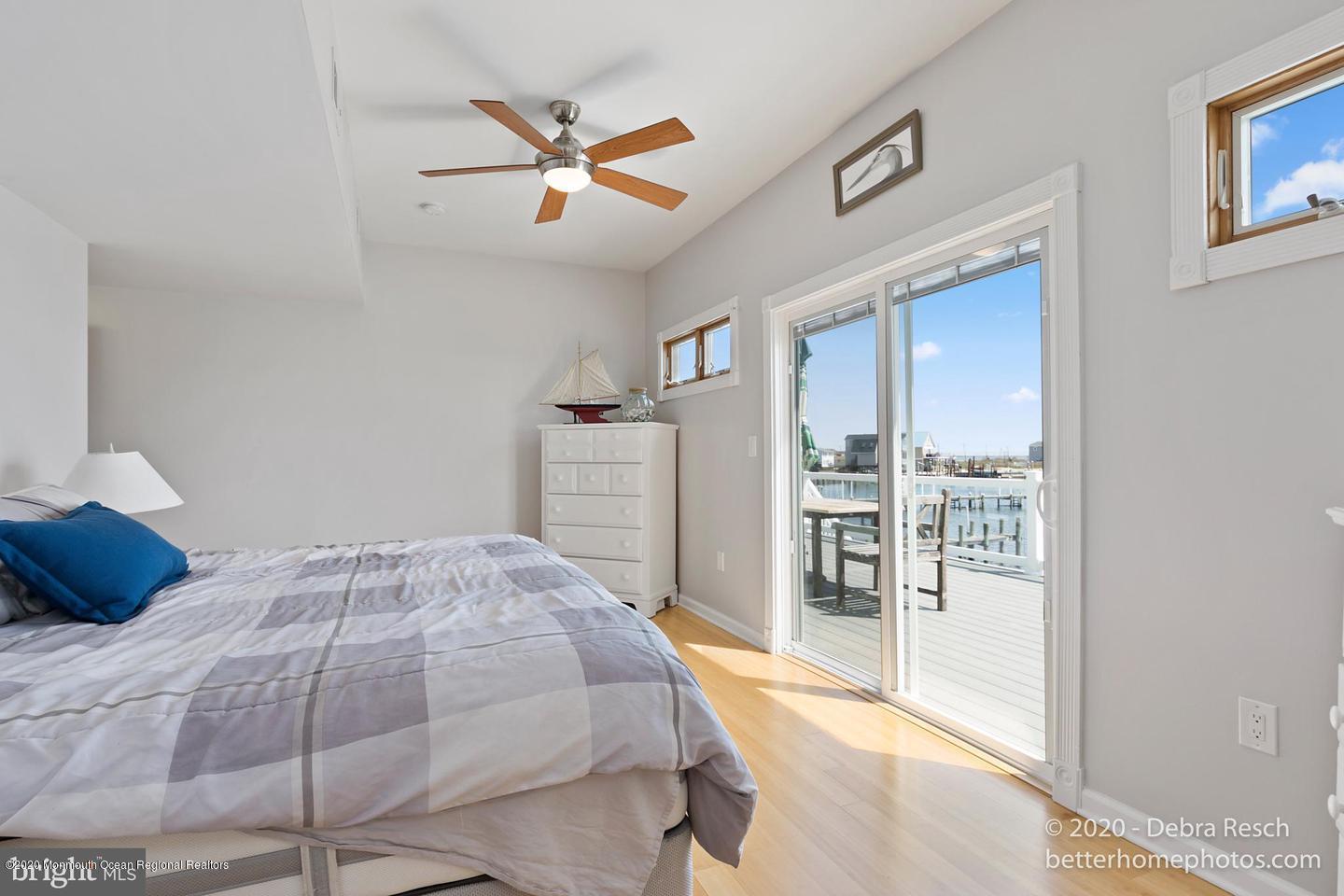 107 Parker Road Tuckerton, NJ 08087 - Photo 22 of 37 a bedroom with a large bed and a chandelier