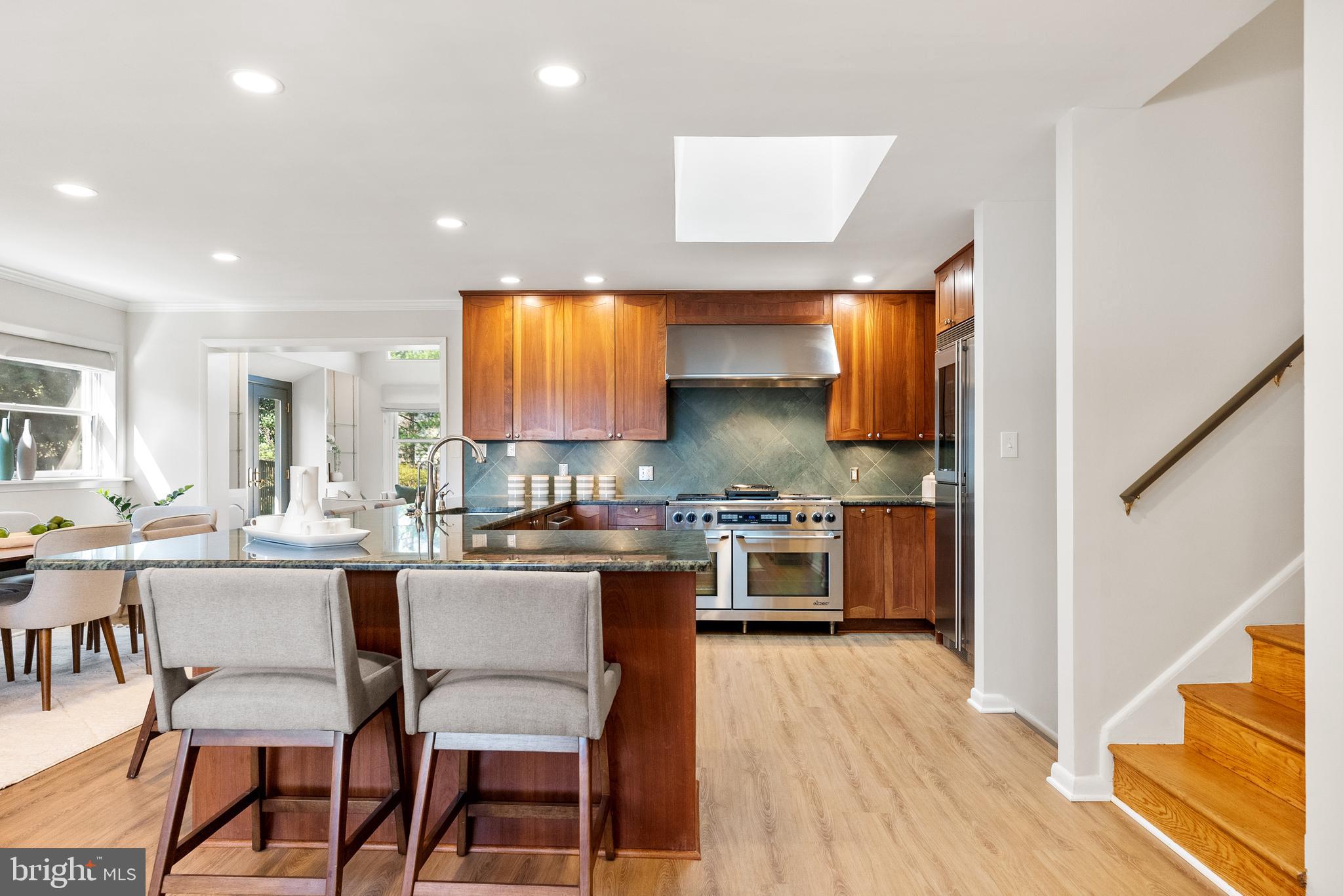 6417 Tone Drive Bethesda, MD 20817 - Photo 6 of 50 a kitchen with stainless steel appliances a stove a sink a oven a dining table and chairs