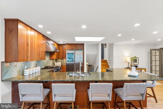 a kitchen with a dining table chairs sink and granite counter top